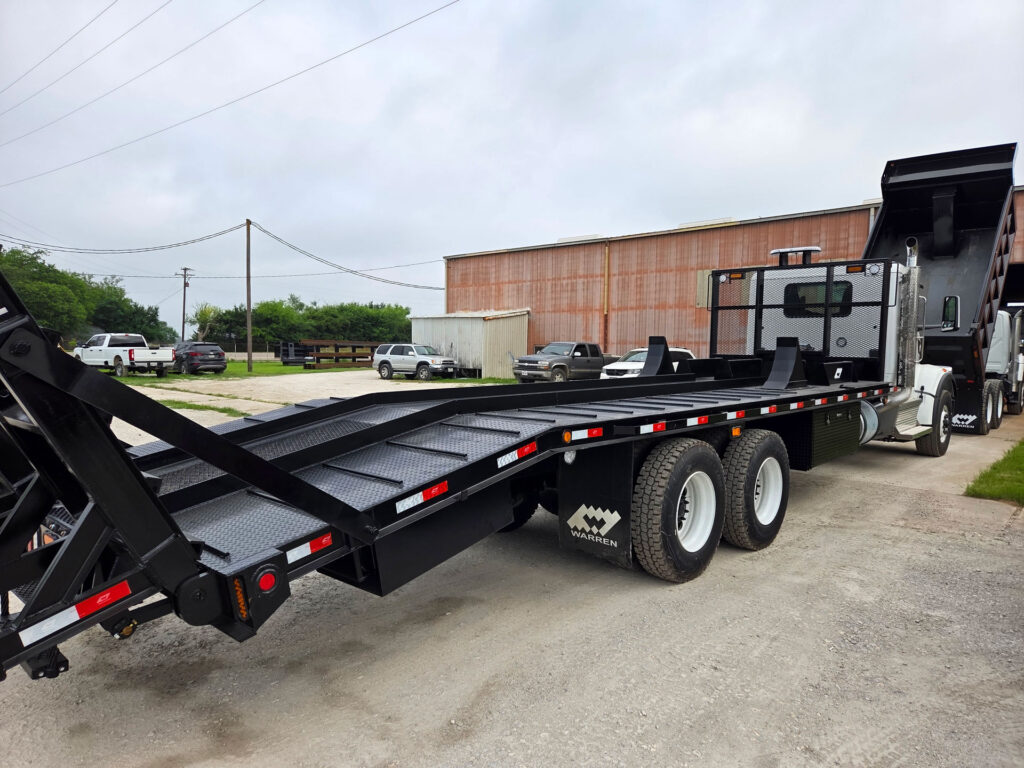 Platform forestry body mounted on a Peterbilt chassis with ramps lowered for equipment loading